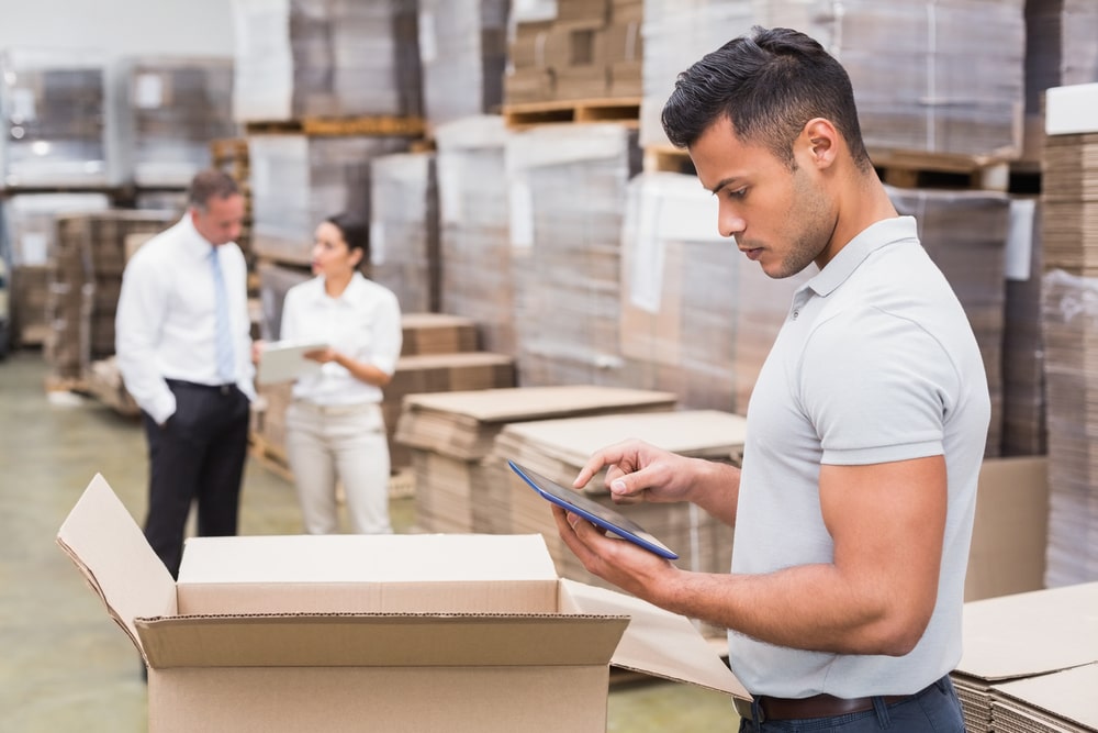 Portrait of male manager using digital tablet in warehouse-min